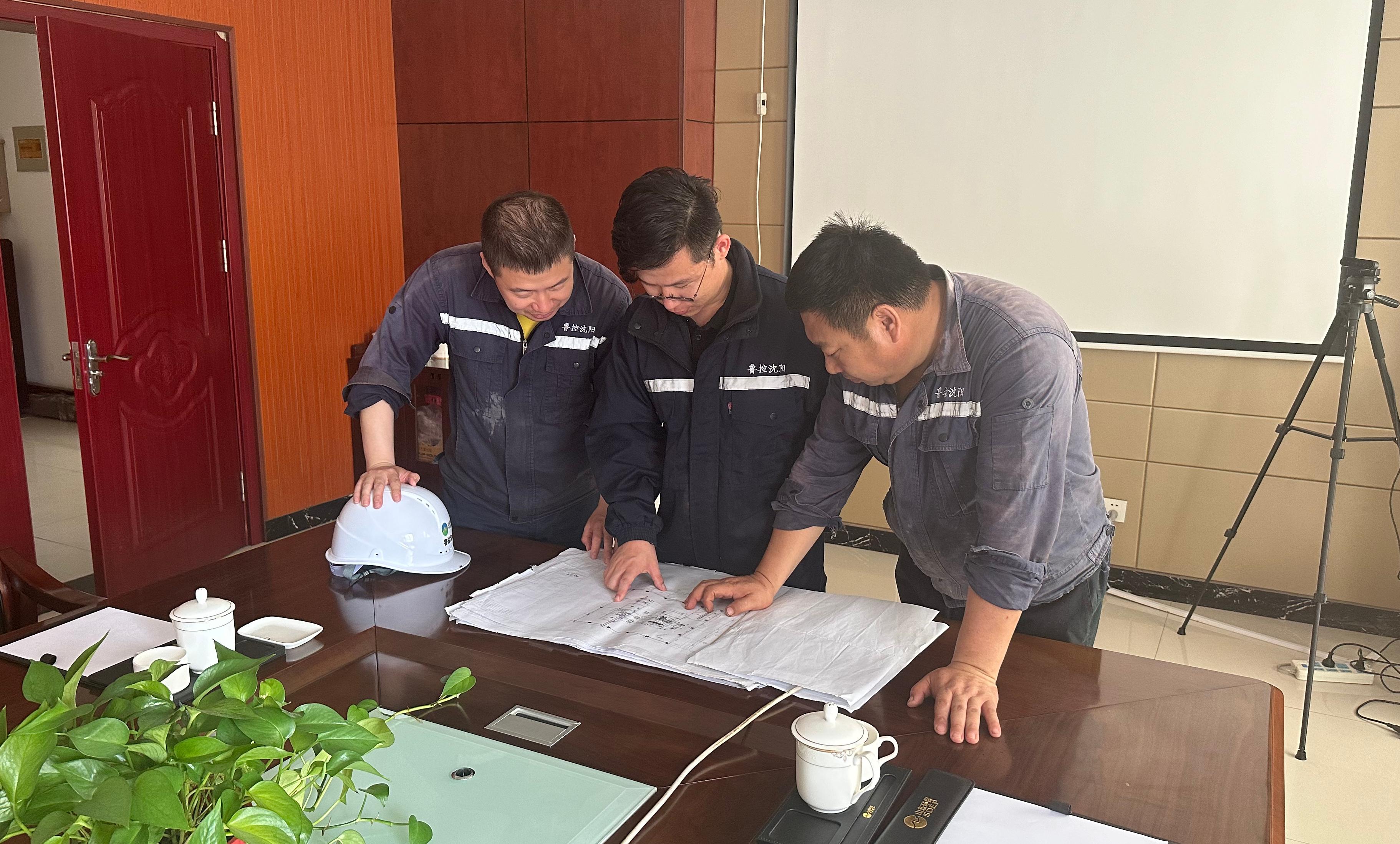 孫茂(中間)與同事研究篩分機調(diào)整方案.jpg
